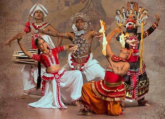 "Group of Sri Lankan dancers in traditional dress performing cultural activity, spitting fire and playing drums."