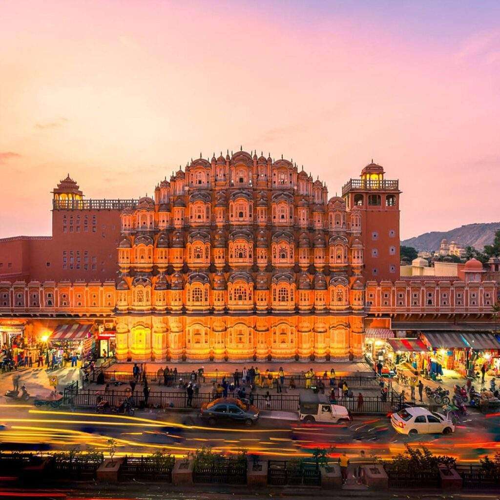 Hawa Mahal, a historic palace in Jaipur, India, glittering at night under illuminated lights."