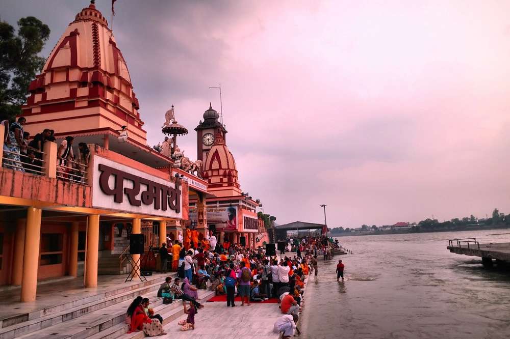 "Tourists engaging in spiritual activities and prayer at Parmarth Niketan in Rishikesh."