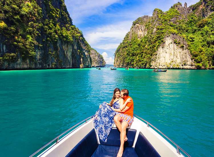 Romantic couple enjoying a boat ride in Krabi, Thailand, cuddling and admiring the beautiful scenery around them.