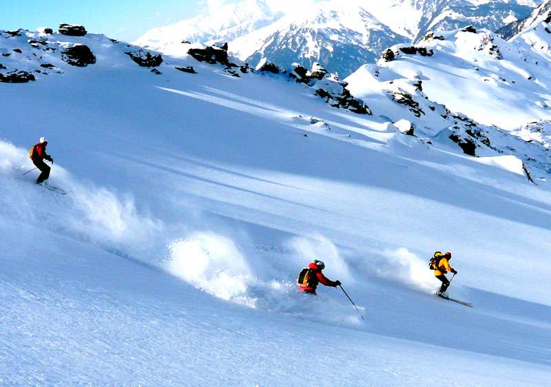 "A skiers glide down the snow-covered slopes surrounded by picturesque mountain scenery in Uttarakhand."