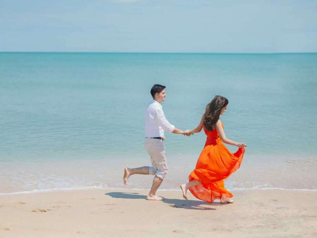 Honeymoon couples enjoying a romantic beach getaway in the picturesque Andaman and Nicobar Islands, relishing in the beauty of the pristine beaches and turquoise waters."