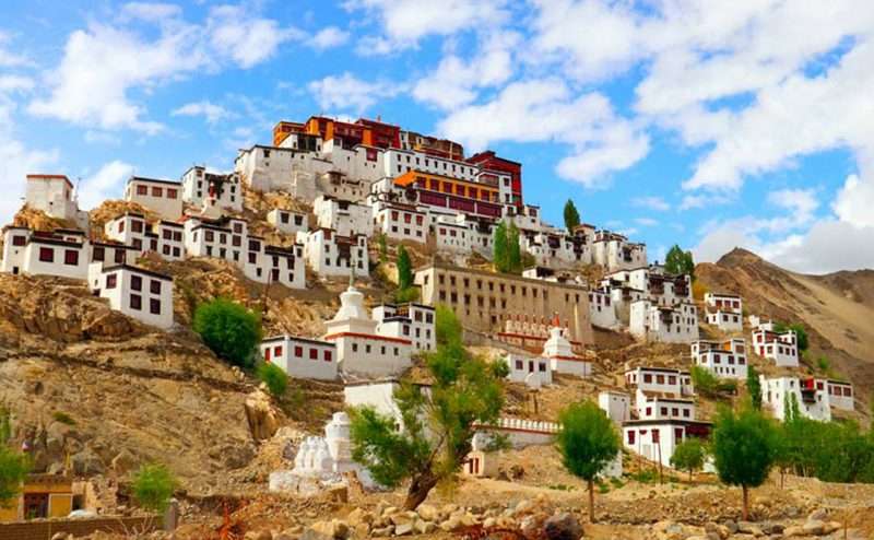 "Exterior view of Alchi Monastery - Choskhor in Leh Ladakh, India with Tibetan-style architecture and prayer flags in the foreground."