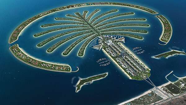 Aerial view of Palm Jumeirah showcasing its palm-shaped design, luxury resorts, pristine beaches, and sparkling blue waters - an iconic destination in Dubai."