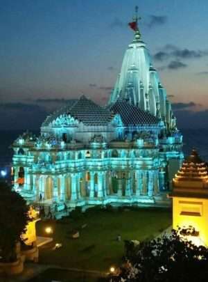 "Shree Somnath Jyotirling Temple at night with illuminated architecture and reflection on water"