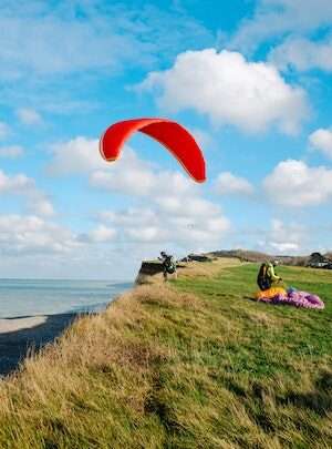 "Tourist running on a hill, getting ready for an exciting paragliding adventure"