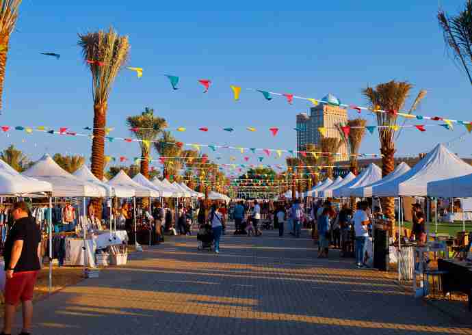 "Busy street market in Dubai with locals shopping during the day"