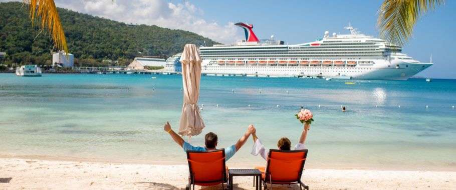 "Two friends relaxing on the beach, gazing at a massive cruise ship anchored off the coast of a Caribbean island."