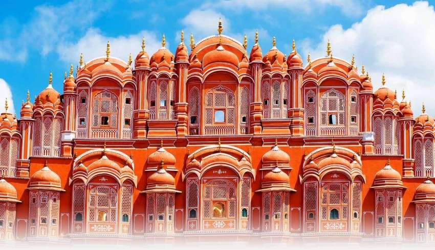 "Facade of the Hawa Mahal palace in Jaipur, India with pink sandstone and many small windows"