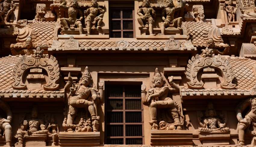 "Brihadeeswara Temple, a large ancient Hindu temple in Thanjavur, Tamil Nadu, India, with a towering pyramidal structure and intricate stone carvings".