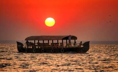 "Boat sailing in the backwaters of Kerala with an orange sunset in the background - South India"