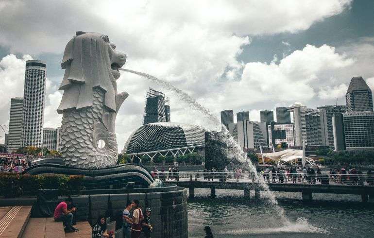 The Merlion fountain in Singapore with the iconic Merlion statue spouting water from its mouth into the pool below.