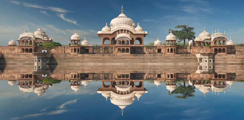 "Radha Kund, also known as Kusum Sarovar, a holy pond in the town of Govardhan, India, surrounded by trees and temples."