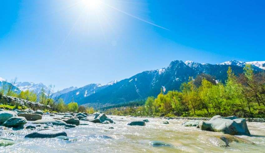 Snow-covered mountains and a river in Manali, India.