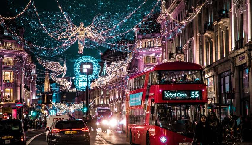 "Christmas lights and red bus passing by in London"