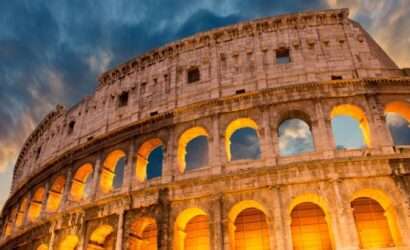 The Colosseum in Rome, Italy, is a grand amphitheater with rows of arches, towering over the surrounding city.