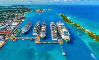 "Five Royal Caribbean cruises docked side by side at a port, ready for passengers to board."