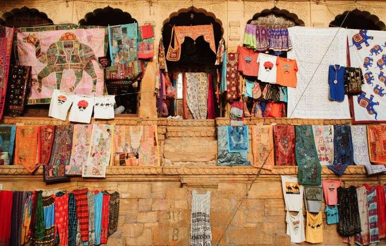 "Rajasthani dresses hanging on the wall of a street shop in Jaisalmer cultural bazaar"