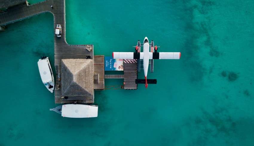 "Private plane and boats on the wooden pathway in Maldives"