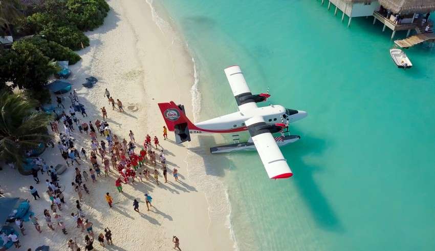 "Private plane and boats resting on the shores of Maldives"