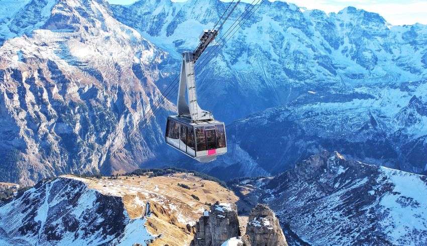 "Two people riding the ropeway with a view of the mountains"