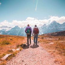 "Two tourists hiking towards snow-covered hill in Uttarakhand."